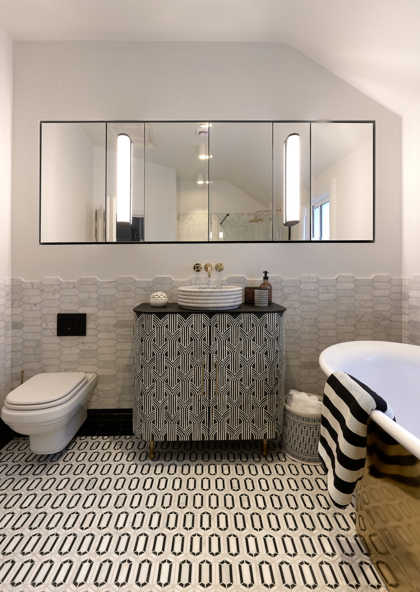 The Townhouse — bathroom with hexagon marble floor, patterned vanity and full-width mirror