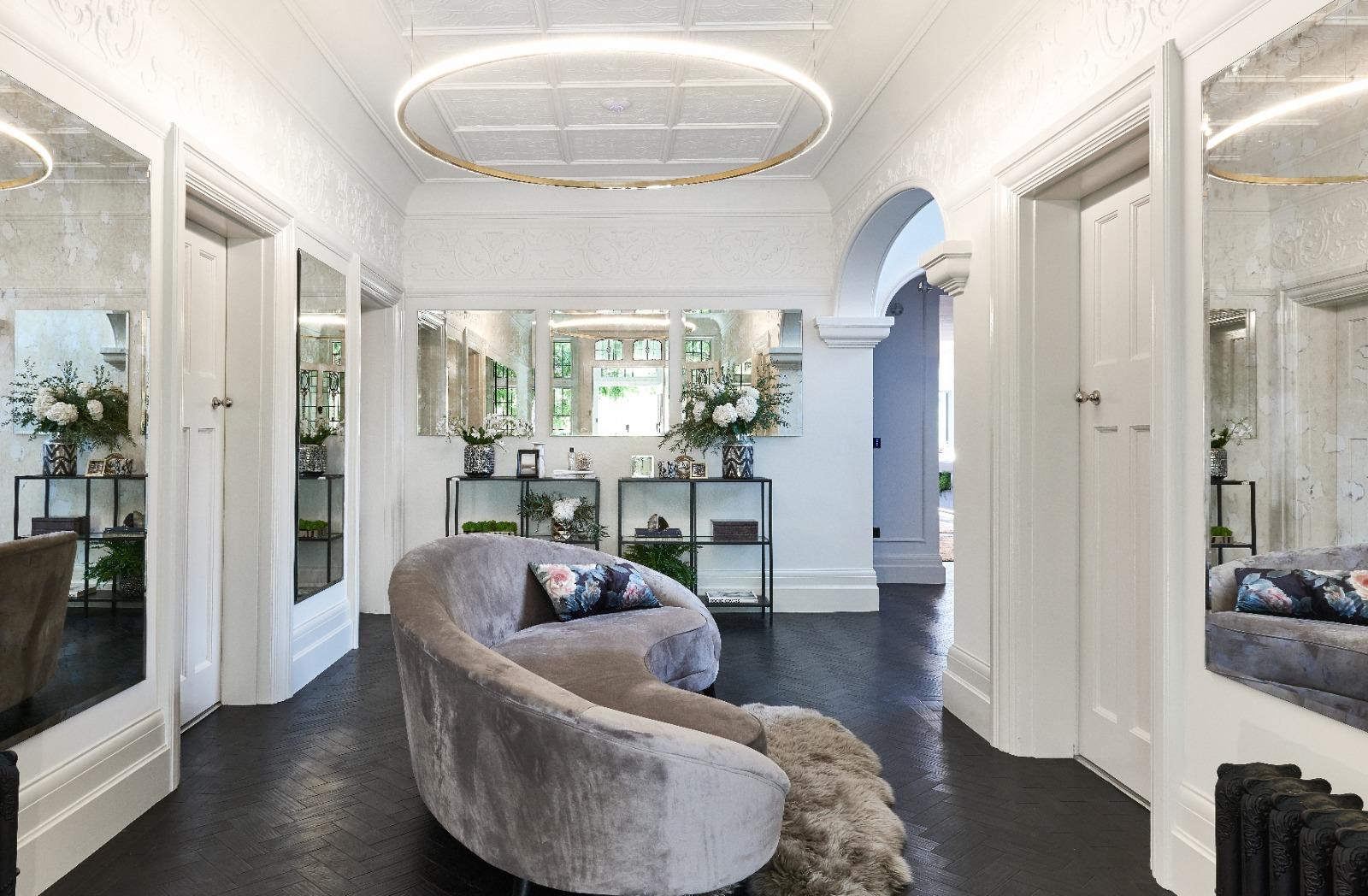 The House on the Park — mirrored hall with brass halo pendant and dark chevron parquet