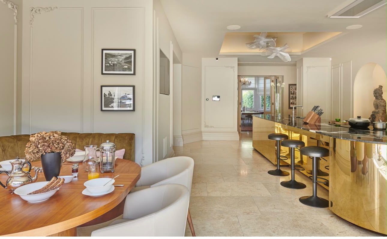 The Residence — dining threshold with brass island beyond